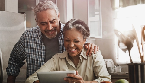 Couple using digital tablet in kitchen
