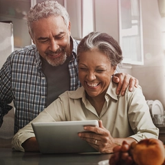 Couple using digital tablet in kitchen