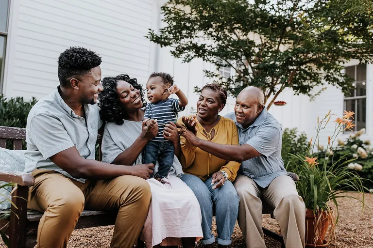 Family sitting on bench together outside