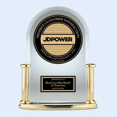 Studio product photograph of a JD Power customer satisfaction award trophy presented to BlueCross BlueShield of Tennessee. The arched clear award features gold-toned columns and a circular black-and-gold medallion displaying “Highest Customer Satisfaction,” “Medicare Advantage,” “Tennessee,” and “2026.” Isolated on a light gray background.