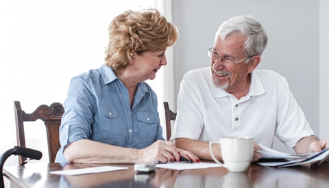Senior couple reviewing documents at kitchen table