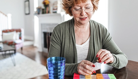 Senior woman sitting at home sorting medication