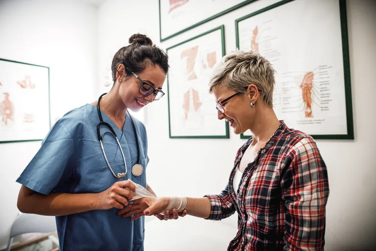 Female Doctor Treating Female Patient's Injury