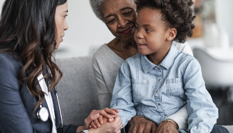 Child Talking to Doctor While Sitting in Granparent's Lap