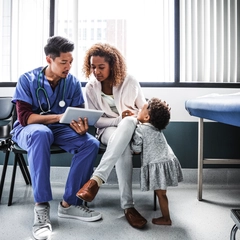 Doctor showing mother test results on a tablet