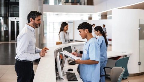 Man talking to receptionist in medical facility