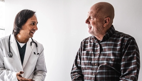 Doctor discussing treatment with senior man in exam room