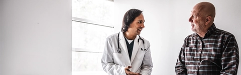 Doctor discussing treatment with senior man in exam room