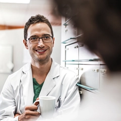 Doctor Consulting with a colleague while drinking coffee