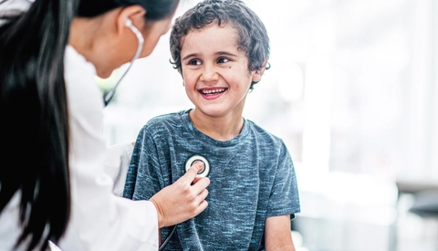 Female doctor checking young boy's heart rate